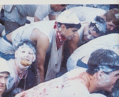 Pollywogs with faces painted and covered in lard during the Shellback initiation aboard USS Belleau Wood, April 1989